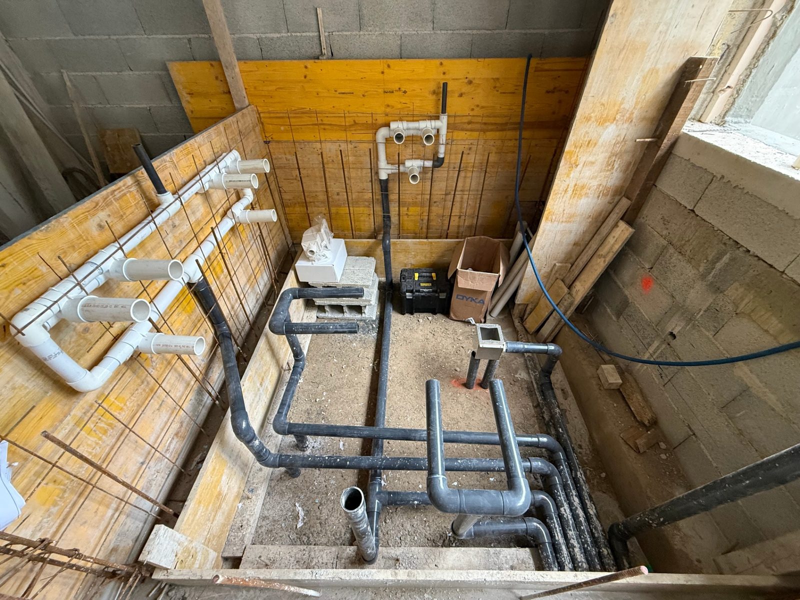 Coffrage en chantier avec les canalisations et les attentes hydrauliques en place